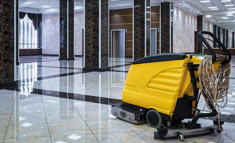 Gele scrobmachine op schoonmaakte vloer