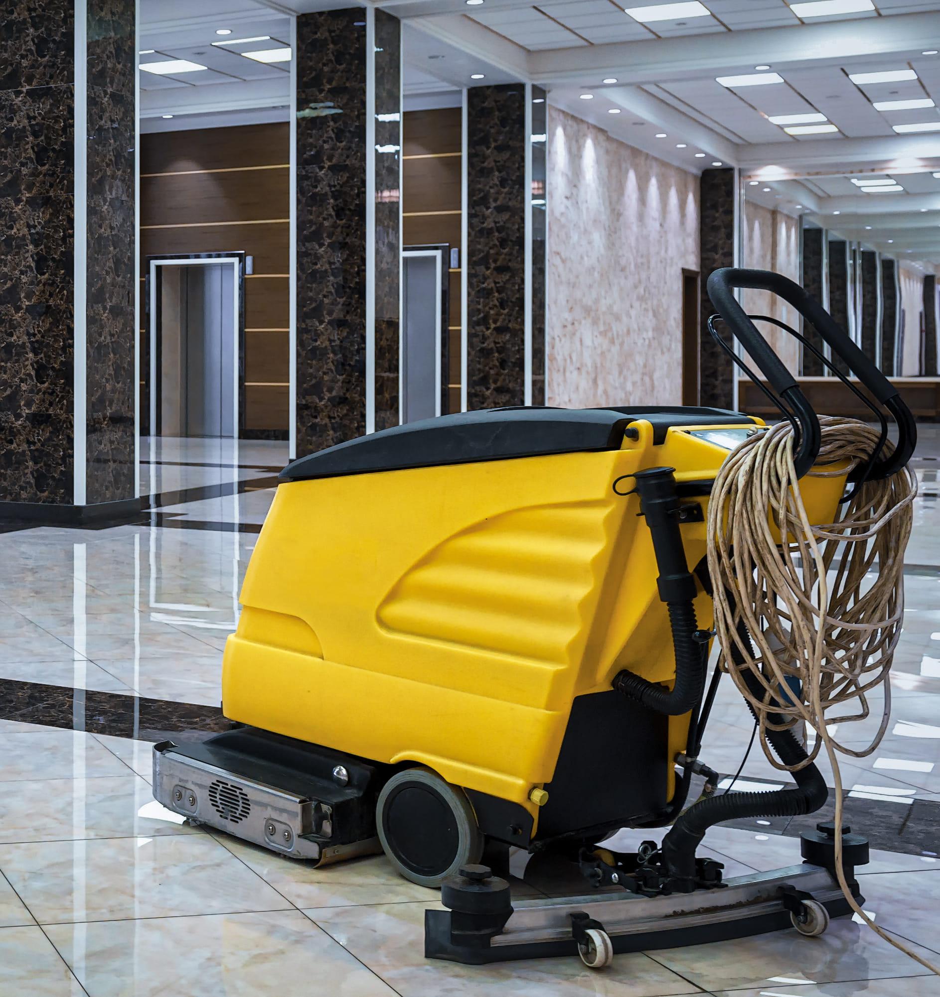 Gele scrobmachine op schoonmaakte vloer